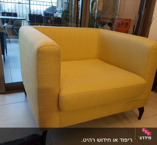 כורסה מרופדת בצבע צהוב עם רגליים כהות